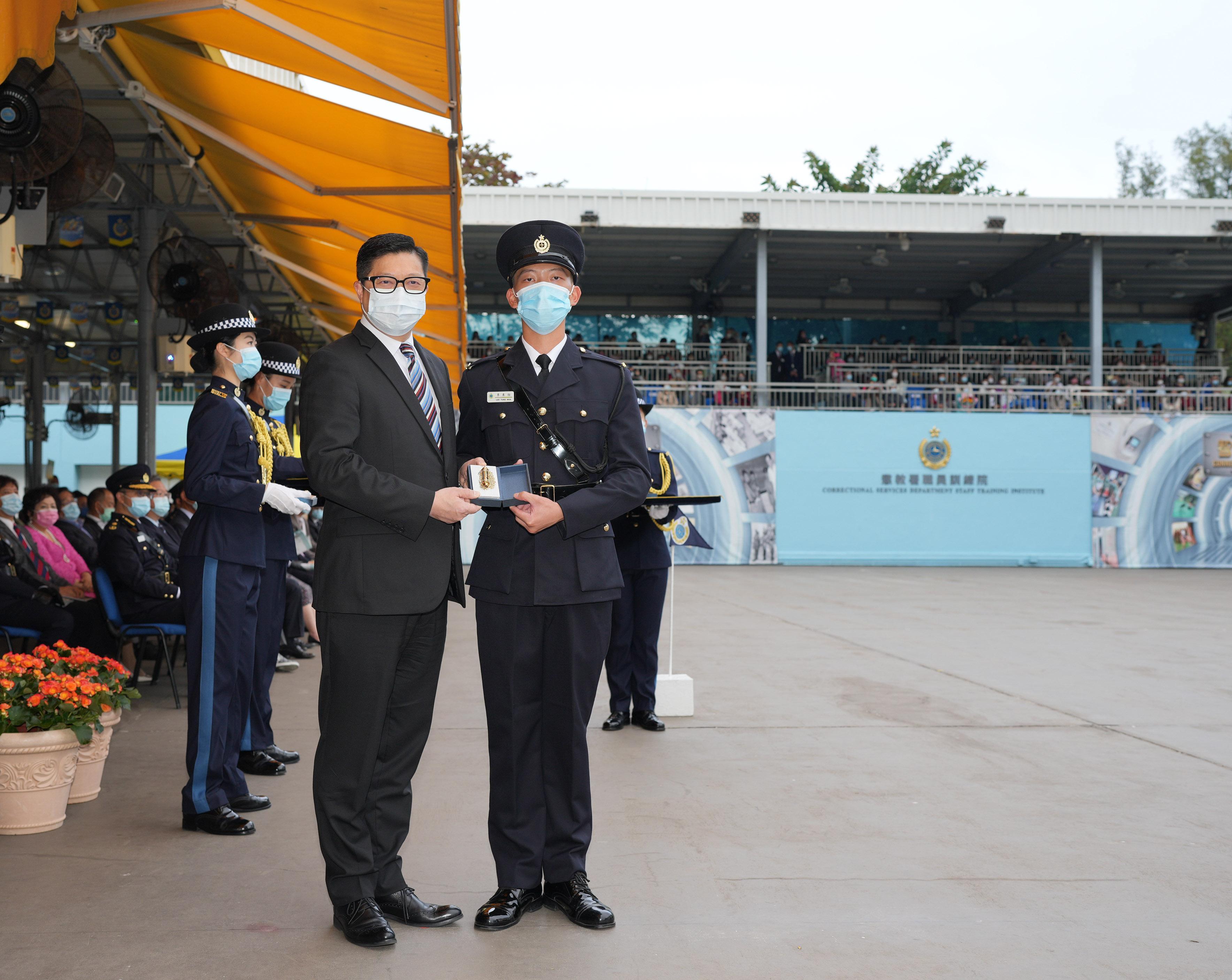 The Correctional Services Department held a passing-out parade at the Staff Training Institute in Stanley today (December 17). Photo shows the Secretary for Security, Mr Tang Ping-keung (left), presenting a Best Recruit Award, the Golden Whistle, to Assistant Officer II Mr Li Tung-wun.