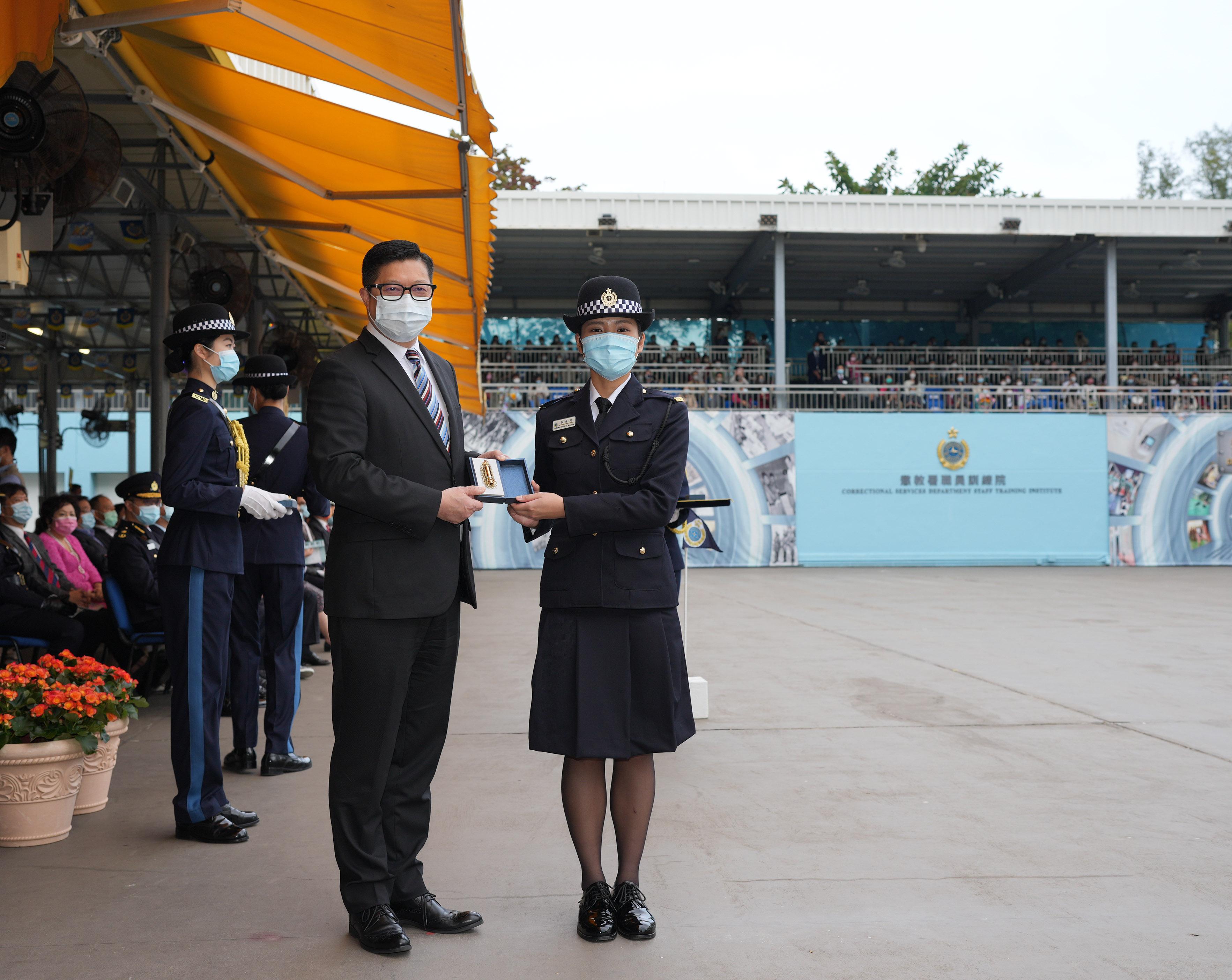 The Correctional Services Department held a passing-out parade at the Staff Training Institute in Stanley today (December 17). Photo shows the Secretary for Security, Mr Tang Ping-keung (left), presenting a Best Recruit Award, the Golden Whistle, to Assistant Officer II Ms Amanda Cheung.