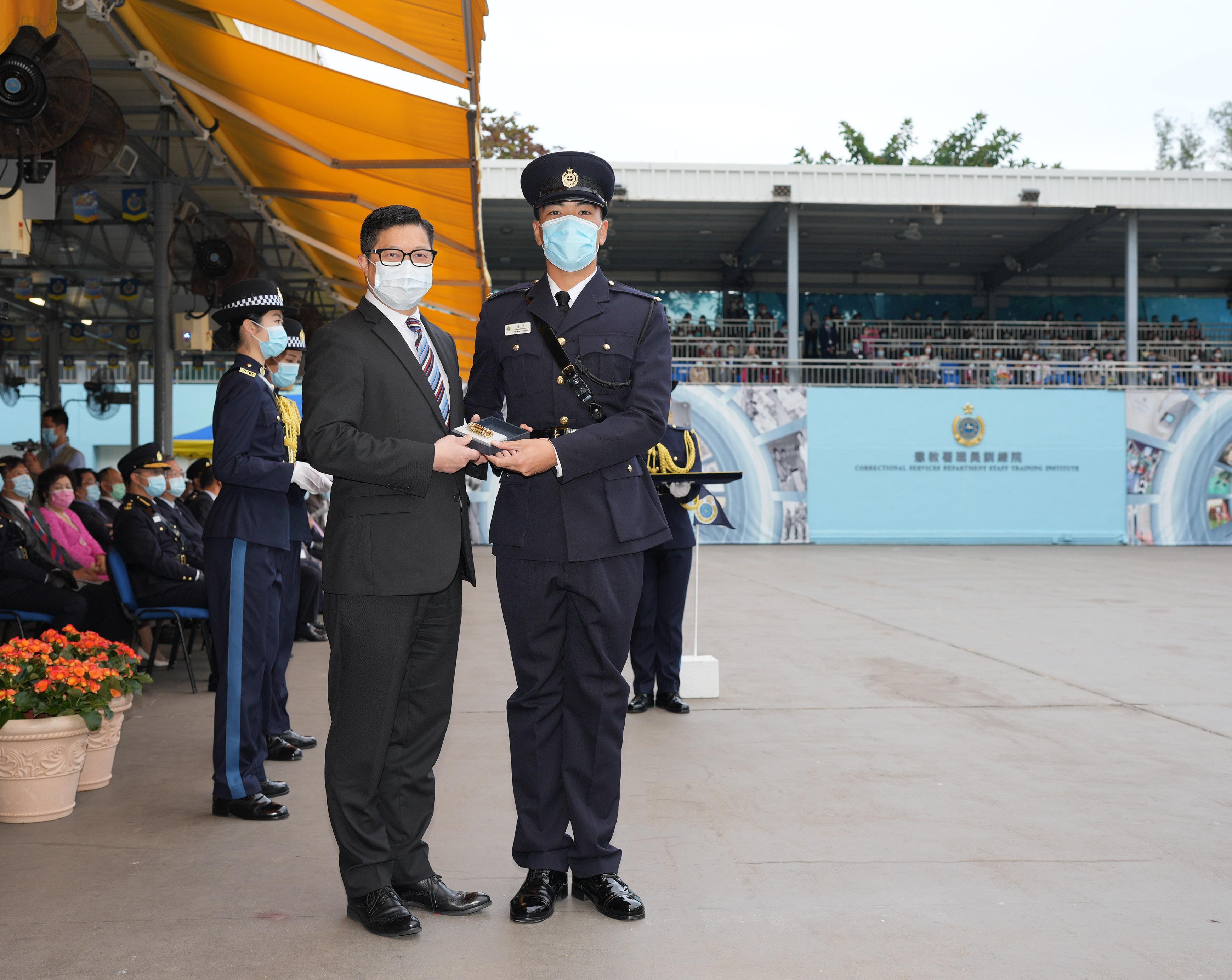 The Correctional Services Department held a passing-out parade at the Staff Training Institute in Stanley today (December 17). Photo shows the Secretary for Security, Mr Tang Ping-keung (left), presenting a Best Recruit Award, the Golden Whistle, to Assistant Officer II Mr Yeung Yeung.