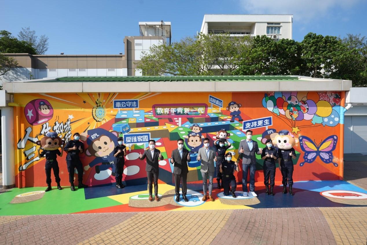 The Correctional Services Department today (December 10) held the Grand Performance cum Open Day at the Hong Kong Correctional Services Academy. Photo shows the Secretary for Security, Mr Tang Ping-keung (sixth right), and the Commissioner of Correctional Services, Mr Wong Kwok-hing (fifth left), Deputy Commissioner of Correctional Services (Operations and Strategic Development), Mr Ng Chiu-Kok (fourth left), Assistant Commissioner of Correctional Services (Rehabilitation), Mr Ho Kwok-man (third right), posing for a group photo with Rehabilitation Pioneer Leaders in front of a three-dimensional mural on the exterior wall of the Community Education Experience Centre.