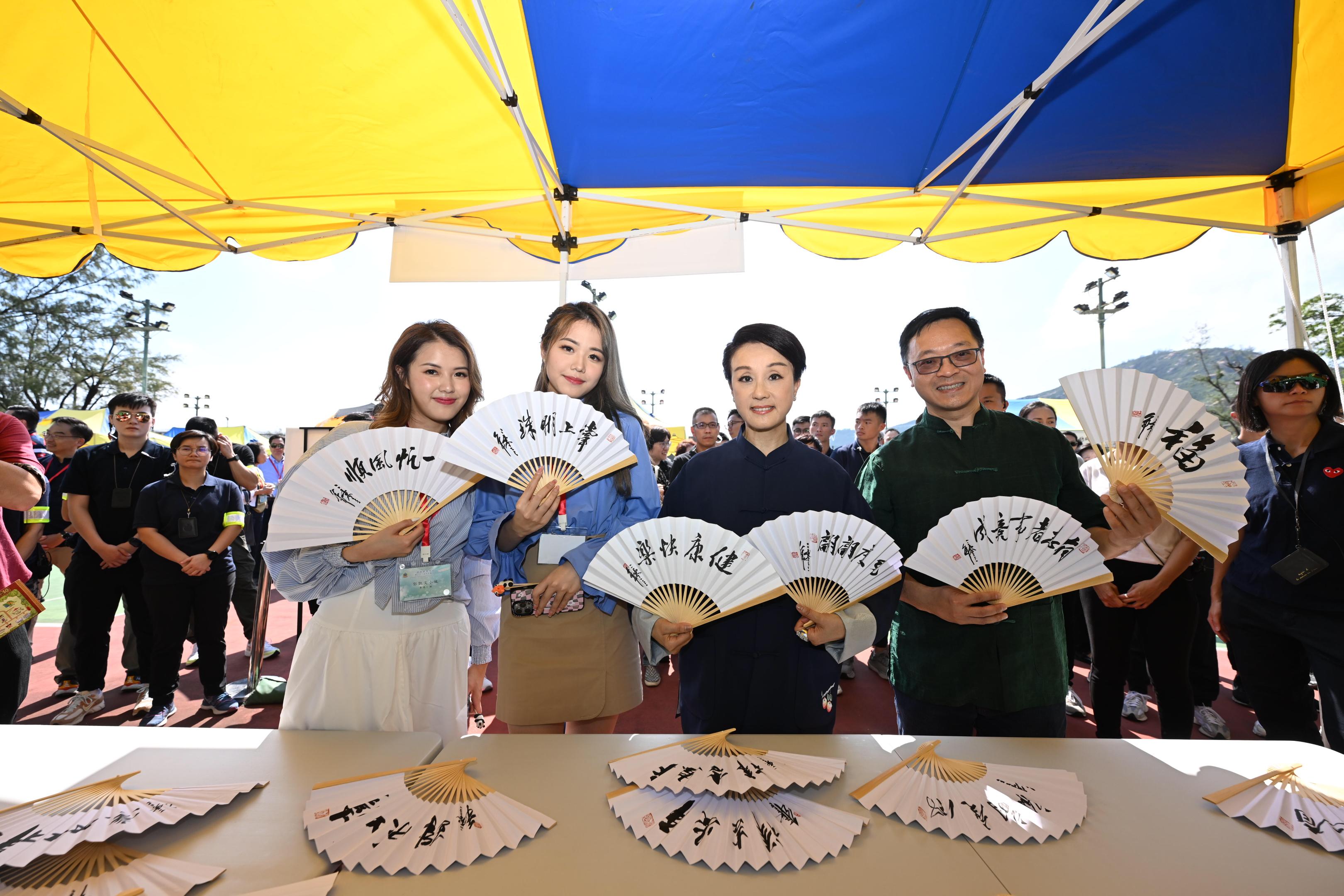 惩教署体育会主办的第六十八届秋季卖物会今日（十一月四日）在赤柱监狱侧足球场举行。图示粤剧名伶盖鸣晖（右二）、惩教署署长黄国兴（右一）及香港小姐2023参观摊位。