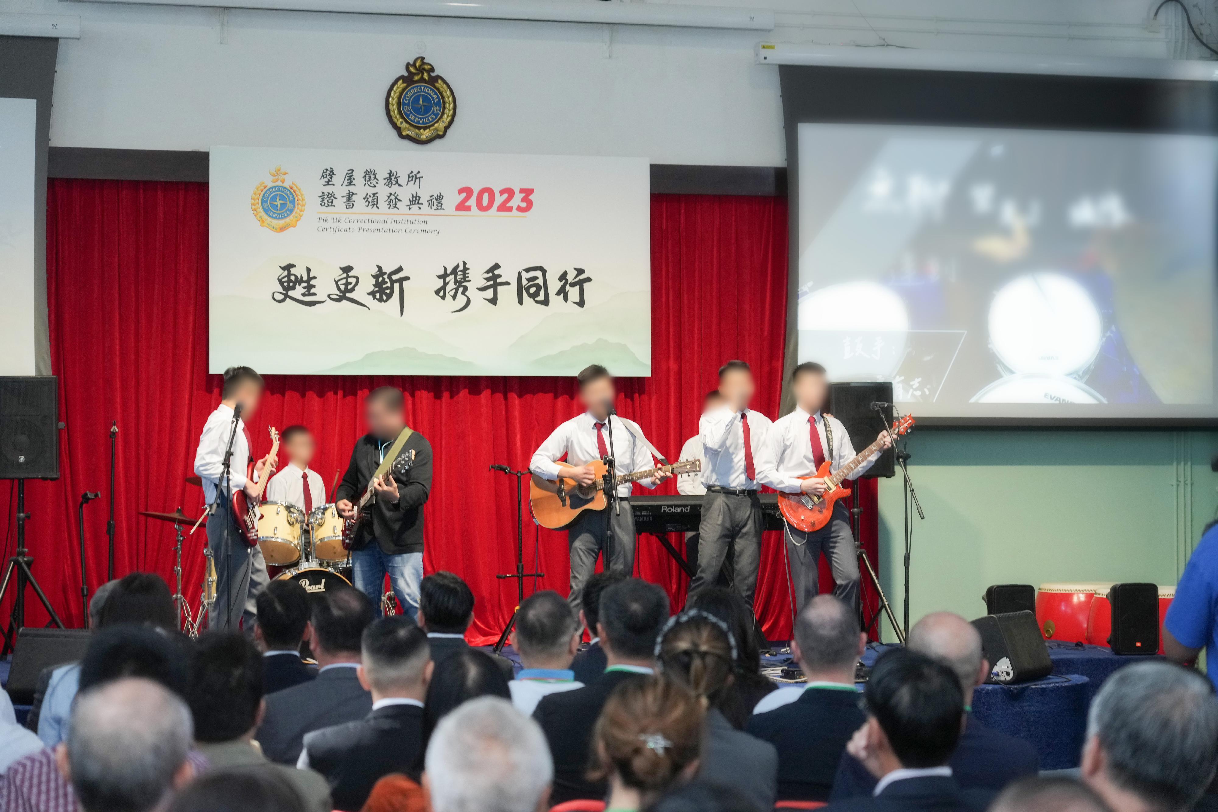 Young persons in custody (PICs) at Pik Uk Correctional Institution of the Correctional Services Department were presented with certificates at a ceremony today (December 7) in recognition of their efforts and achievements in studies and vocational examinations. Photo shows a young PIC and his father, together with other PICs, presenting a music performance onstage at the ceremony.