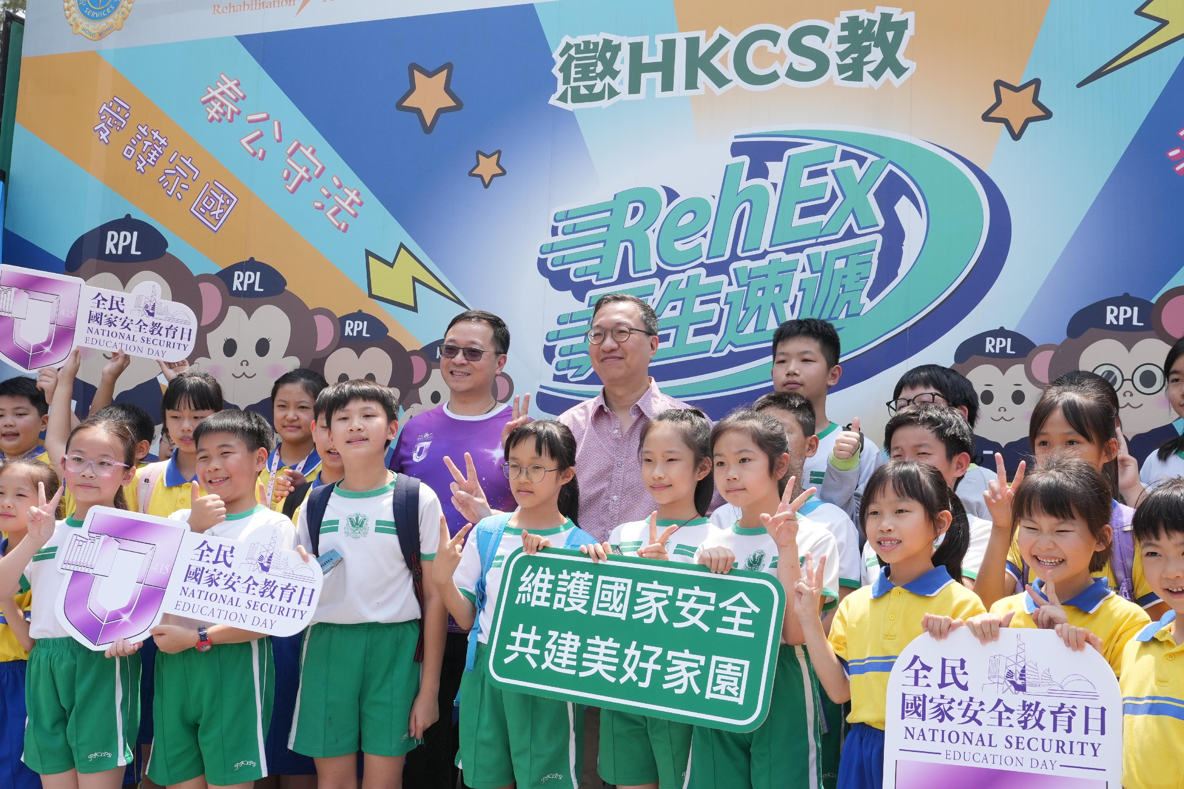 To support National Security Education Day on April 15, the Correctional Services Department held an open day at the Hong Kong Correctional Services Academy today (April 13) to raise public awareness of national security and enhance public understanding of its work in safeguarding national security. Photo shows the Secretary for Justice, Mr Paul Lam, SC (back row, fourth right), and the Commissioner of Correctional Services, Mr Wong Kwok-hing (back row, fifth right), taking photos with students.