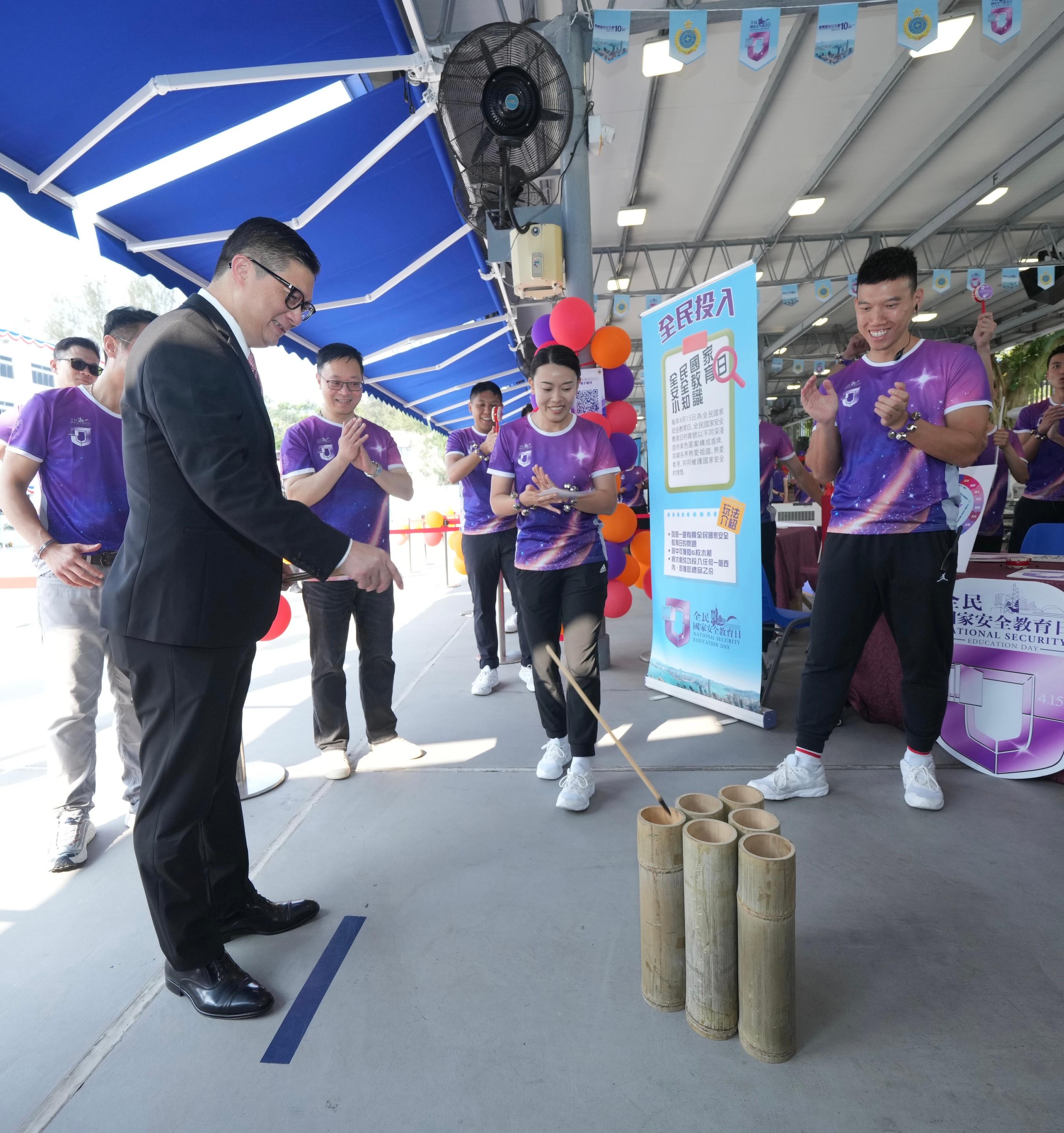 To support National Security Education Day on April 15, the Correctional Services Department held an open day at the Hong Kong Correctional Services Academy today (April 13) to raise public awareness of national security and enhance public understanding of its work in safeguarding national security. Photo shows the Secretary for Security, Mr Tang Ping-keung (first left), accompanied by the Commissioner of Correctional Services, Mr Wong Kwok-hing (second left), playing a booth game.