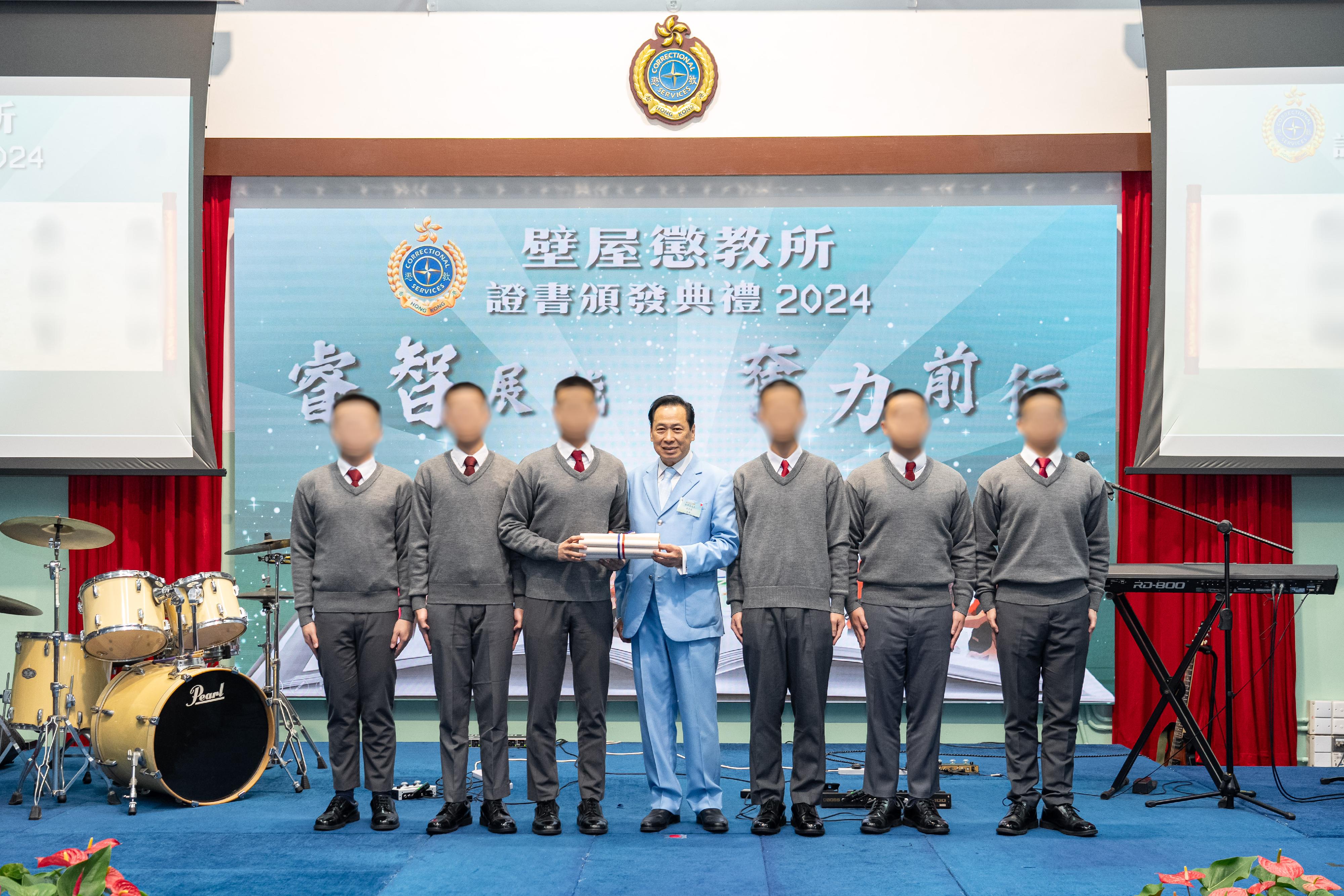 惩教署辖下壁屋惩教所今日（十二月五日）举行证书颁发典礼，颁发证书予青少年在囚人士，以肯定他们在学业及职业训练考试上付出的努力及取得的成果。图示啬色园董事会主席黎泽森（中）在典礼上颁发证书予青少年在囚人士。