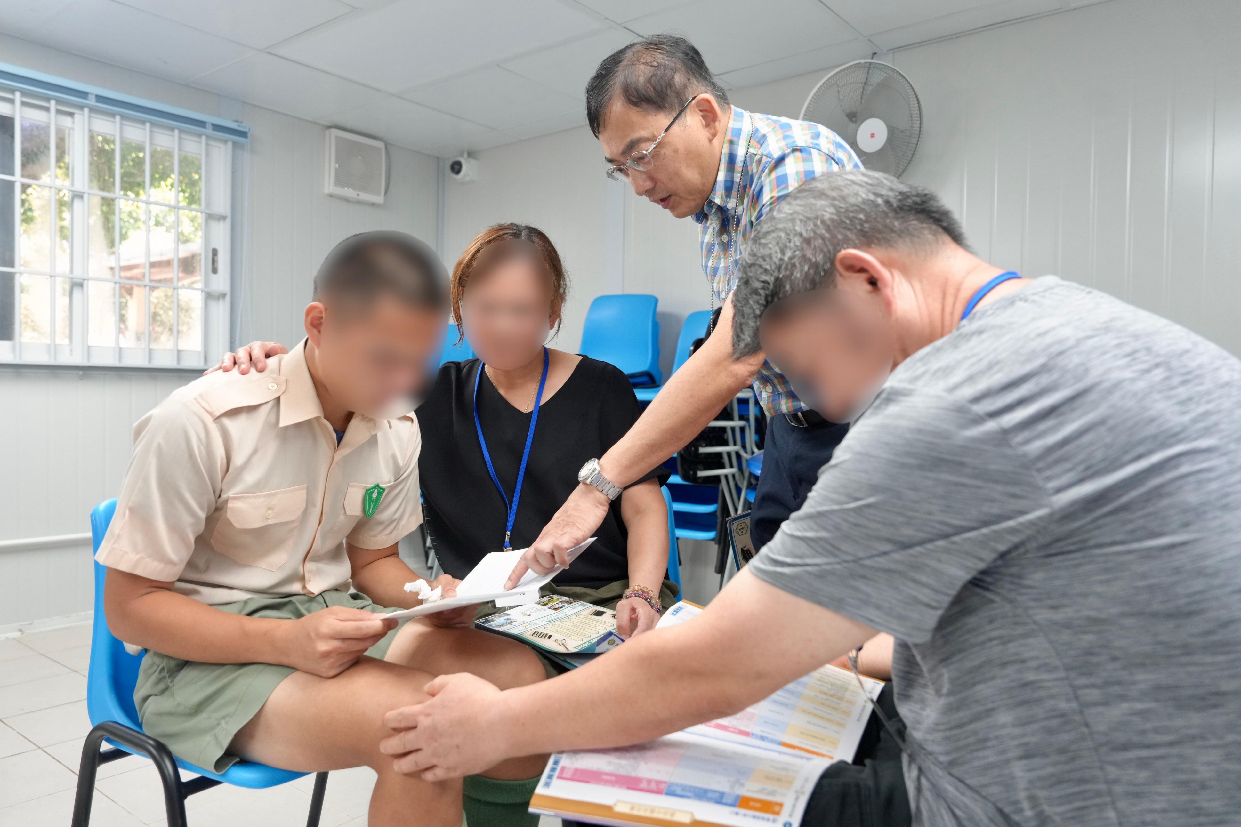 The results of the Hong Kong Diploma of Secondary Education Examination were released today (July 16). Twenty young persons in custody enrolled in the examination this year. Photo shows a young person in custody receiving encouragement from his family members and teacher.
