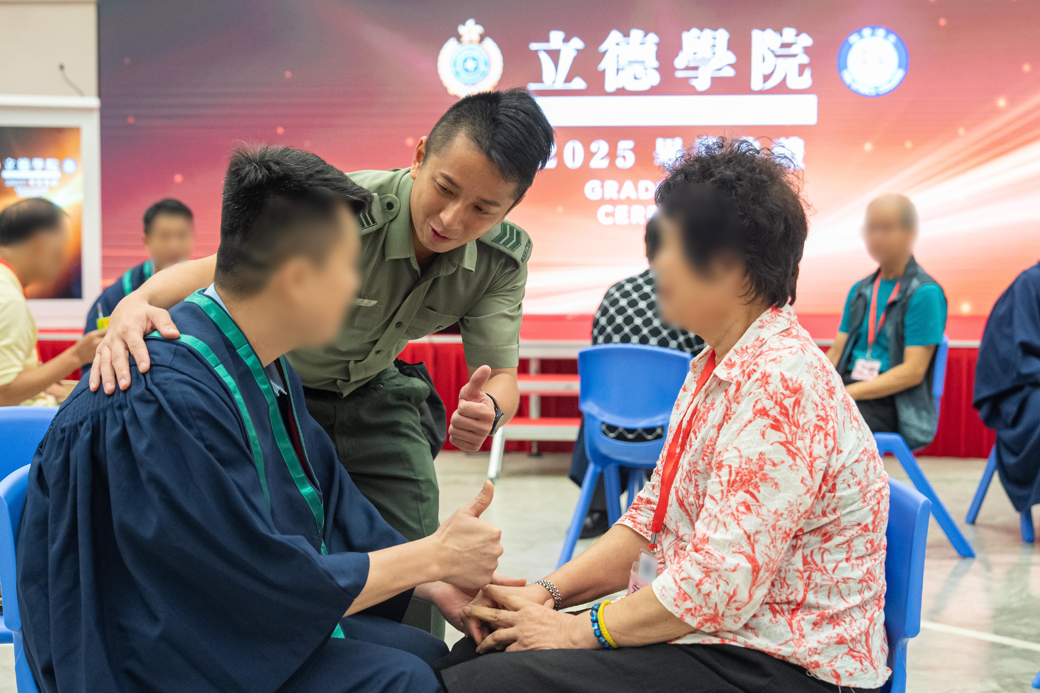 The Correctional Services Department held the second graduation ceremony of the Ethics College at Pak Sha Wan Correctional Institution today (August 6) to present graduation certificates to persons in custody (PICs) who have completed the Diploma of Applied Education programme. Photo shows a PIC graduate expressing gratitude to his family member and a correctional officer for their support and encouragement. 