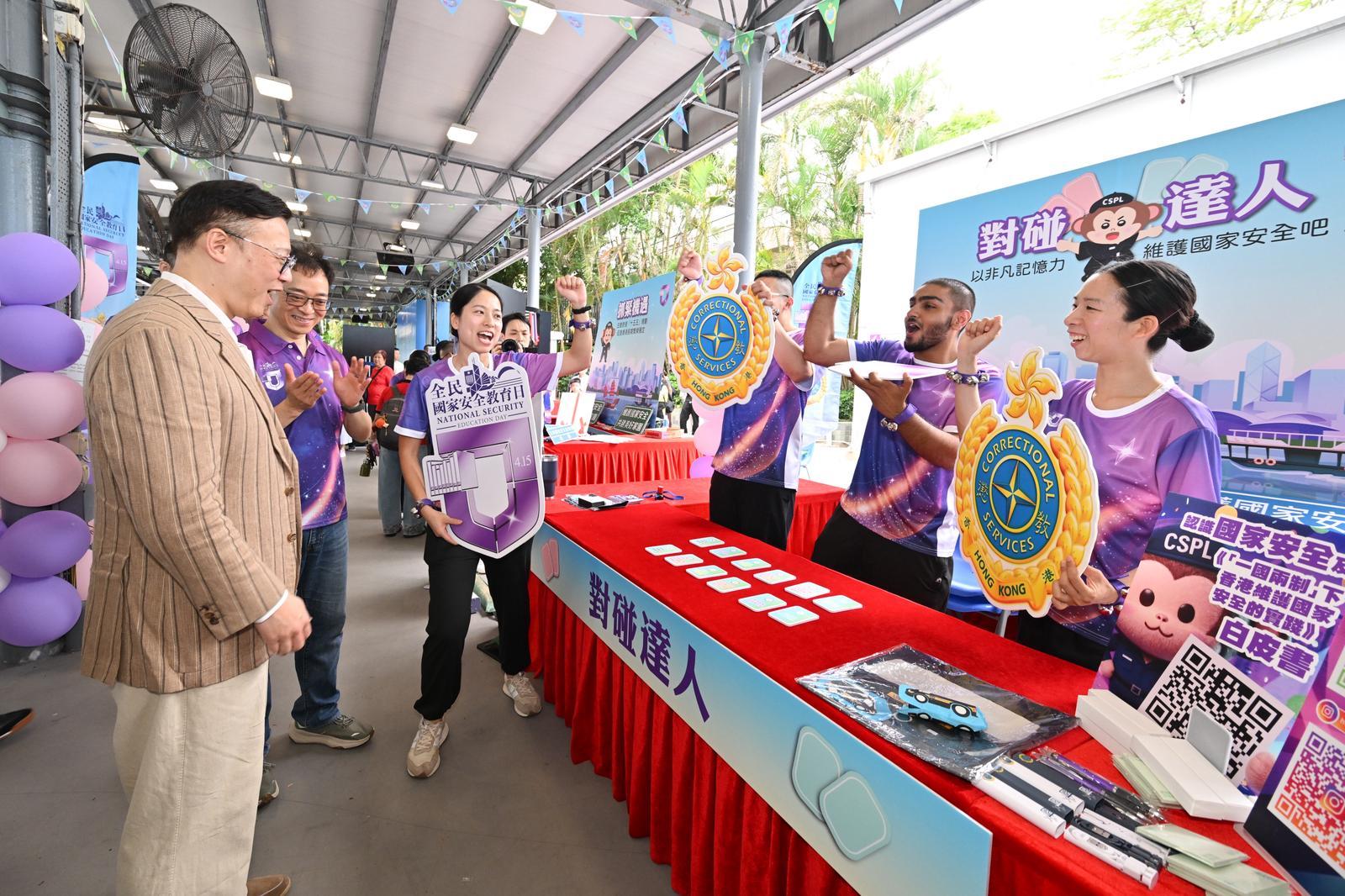 To support the 11th National Security Education Day on April 15 this year, the Correctional Services Department held an open day at the Hong Kong Correctional Services Museum and the Community Education Experience Centre today (April 11). Photo shows the Deputy Secretary for Justice, Dr Cheung Kwok-kwan (left), accompanied by the Commissioner of Correctional Services, Mr Wong Kwok-hing (second left), participating in a booth game centred on the white paper on "Hong Kong: Safeguarding China&rsquo;s National Security Under the Framework of One Country, Two Systems".