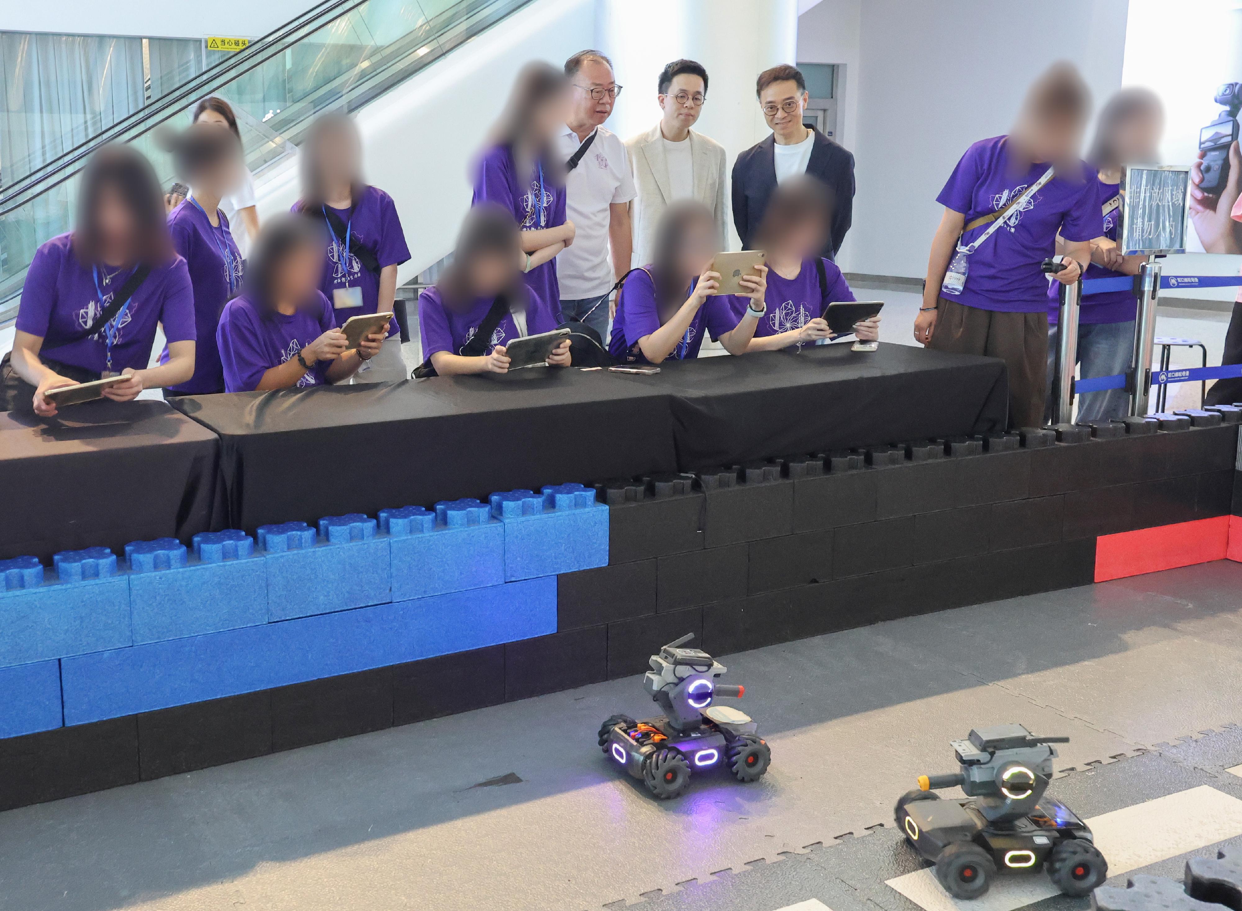 The Correctional Services Department organised another three-day Greater Bay Area Experience Exchange Tour from June 26 to today (June 28), taking young rehabilitated persons to visit various enterprises and places in Shenzhen to learn about the latest developments in innovation and technology in the Guangdong-Hong Kong-Macao Greater Bay Area, as well as the local history and culture. Photo shows young rehabilitated persons, led by the Commissioner of Correctional Services, Mr Wong Kwok-hing (back row, first right) and the tour&rsquo;s sponsor, Mr Kan Kai-wang (back row, second right), experiencing intelligent educational robot operation at Dajiang Innovations Technology Company Limited on June 27.