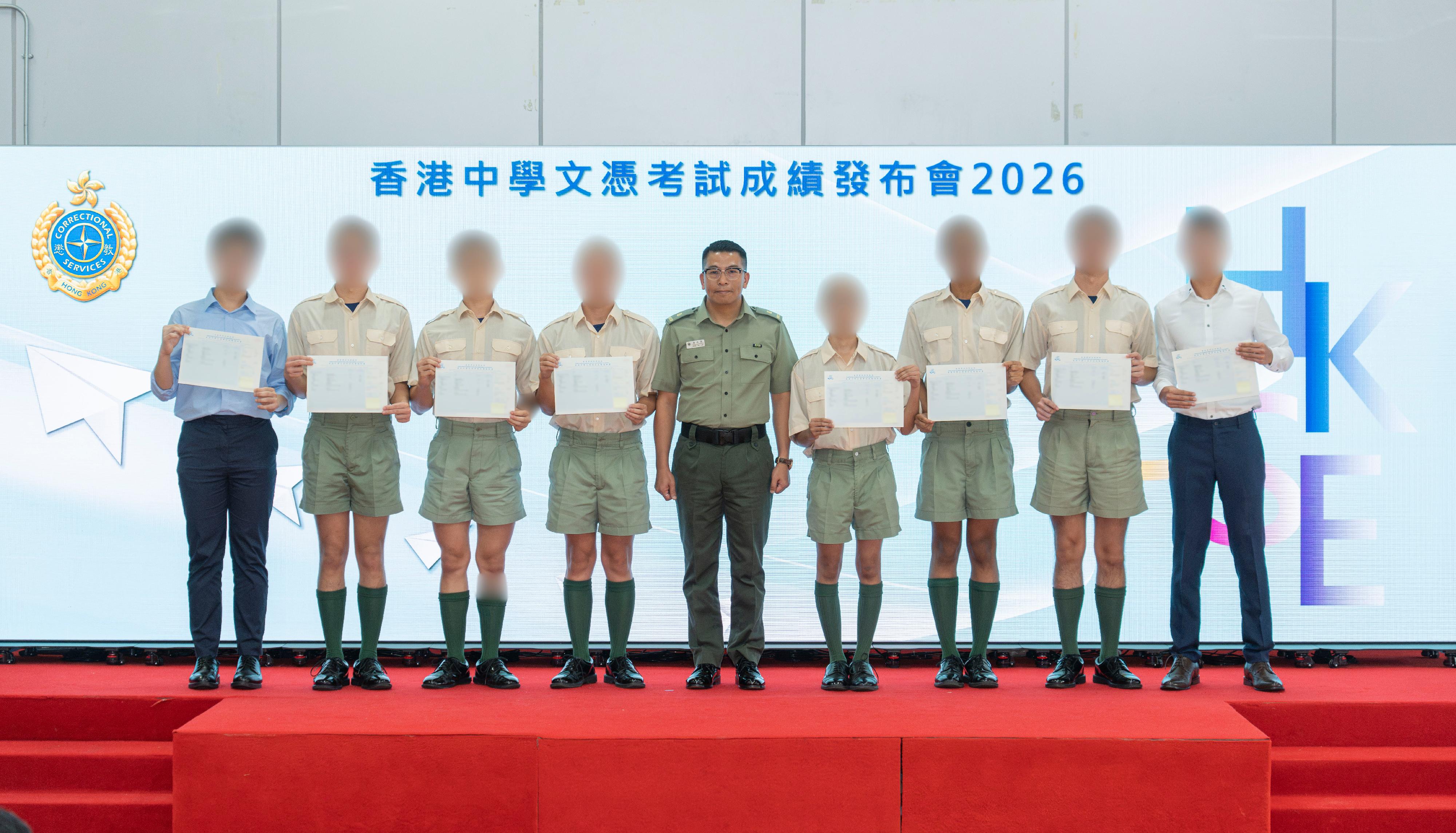 The results of the Hong Kong Diploma of Secondary Education Examination were released today (July 15). The Correctional Services Department held a press conference this morning at Sha Tsui Correctional Institution (STCI) to announce the satisfactory results obtained by young persons in custody who sat for the examination this year. Photo shows the Superintendent of STCI, Mr Poon Ho-lam (centre), with candidates after presenting them with their examination certificates.