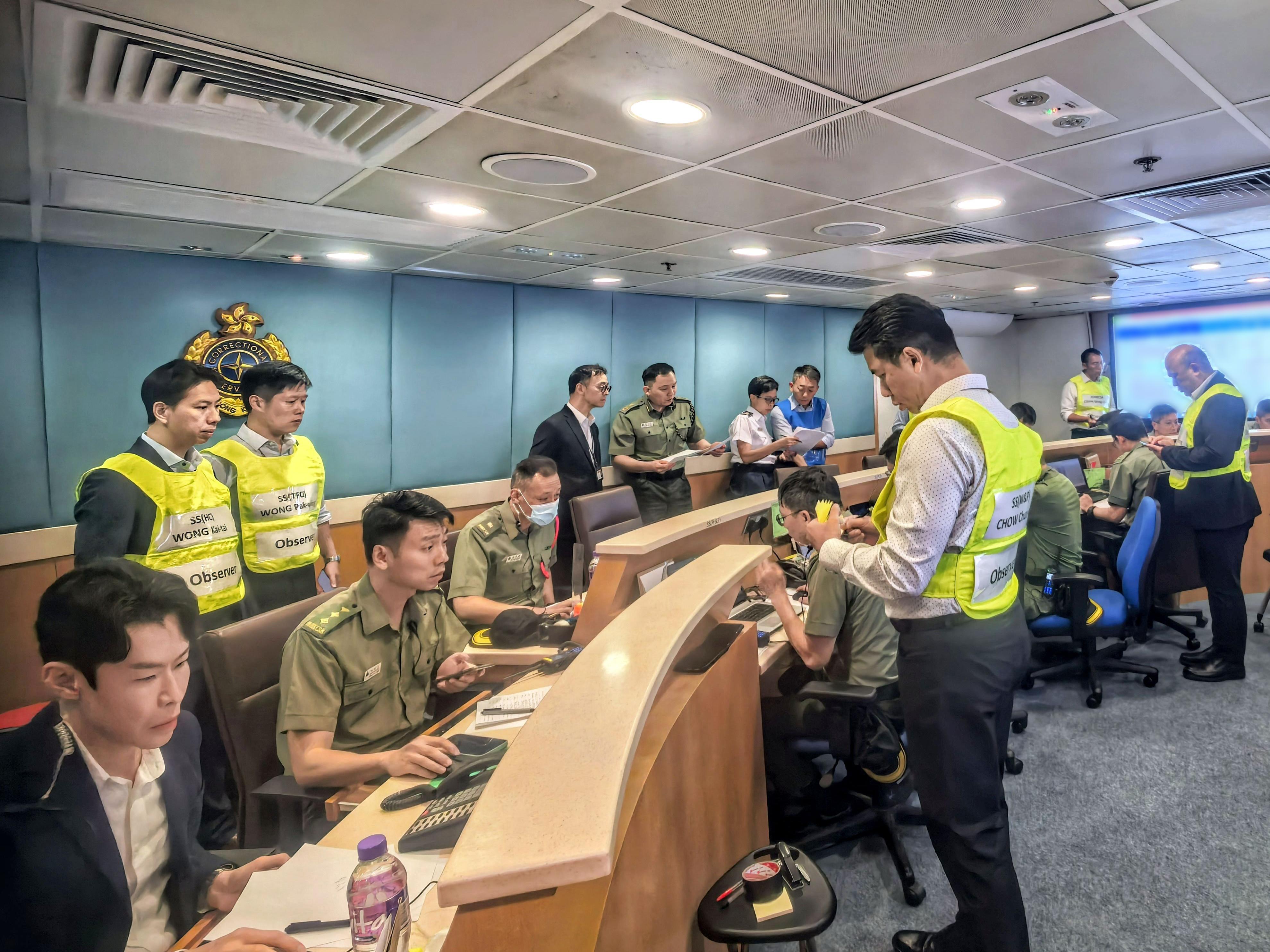 The Correctional Services Department conducted a large-scale emergency exercise, code-named "Concord XXV", at Pik Uk Correctional Institution today (October 21). The exercise simulated a series of incidents, which included fighting among remand persons in custody, a hostage-taking situation, a fire breakout, a mass riot and the discovery of explosives. Photo shows the Commissioner of Correctional Services, Mr Wong Kwok-hing (back row, third left), visiting the Department&rsquo;s Central Control Centre in Stanley and being briefed by the Assistant Commissioner of Correctional Services (Operations), Mr Chan Siu-hang (back row, fourth left), on the operation of the exercise.
