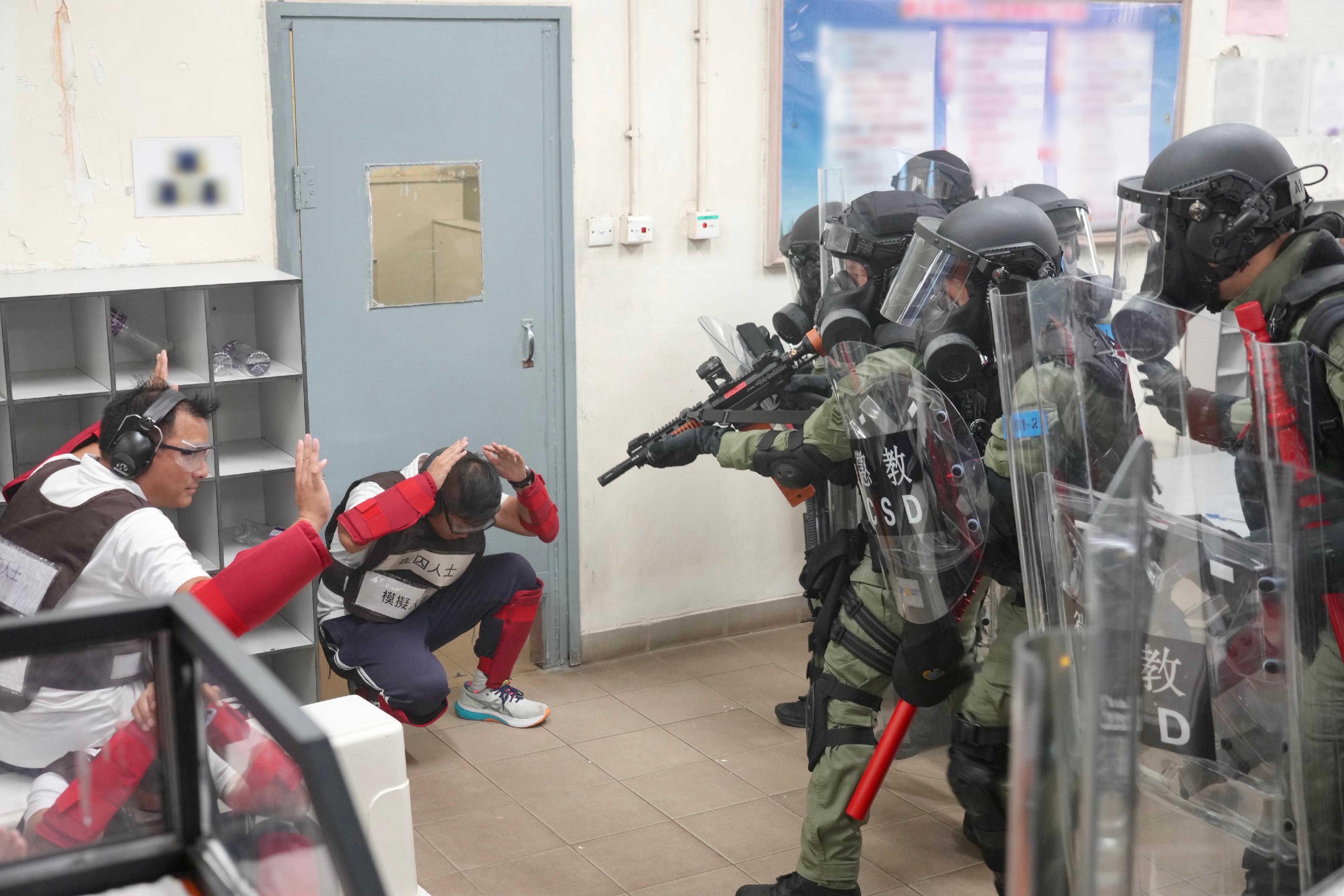 The Correctional Services Department conducted a large-scale emergency exercise, code-named "Concord XXV", at Pik Uk Correctional Institution (PUCI) today (October 21). The exercise simulated a series of incidents, which included fighting among remand persons in custody (PICs), a hostage-taking situation, a fire breakout, a mass riot and the discovery of explosives. Photo shows members of the Regional Response Team breaking into a dining hall of PUCI to subdue remand PICs who have violated discipline regulations.