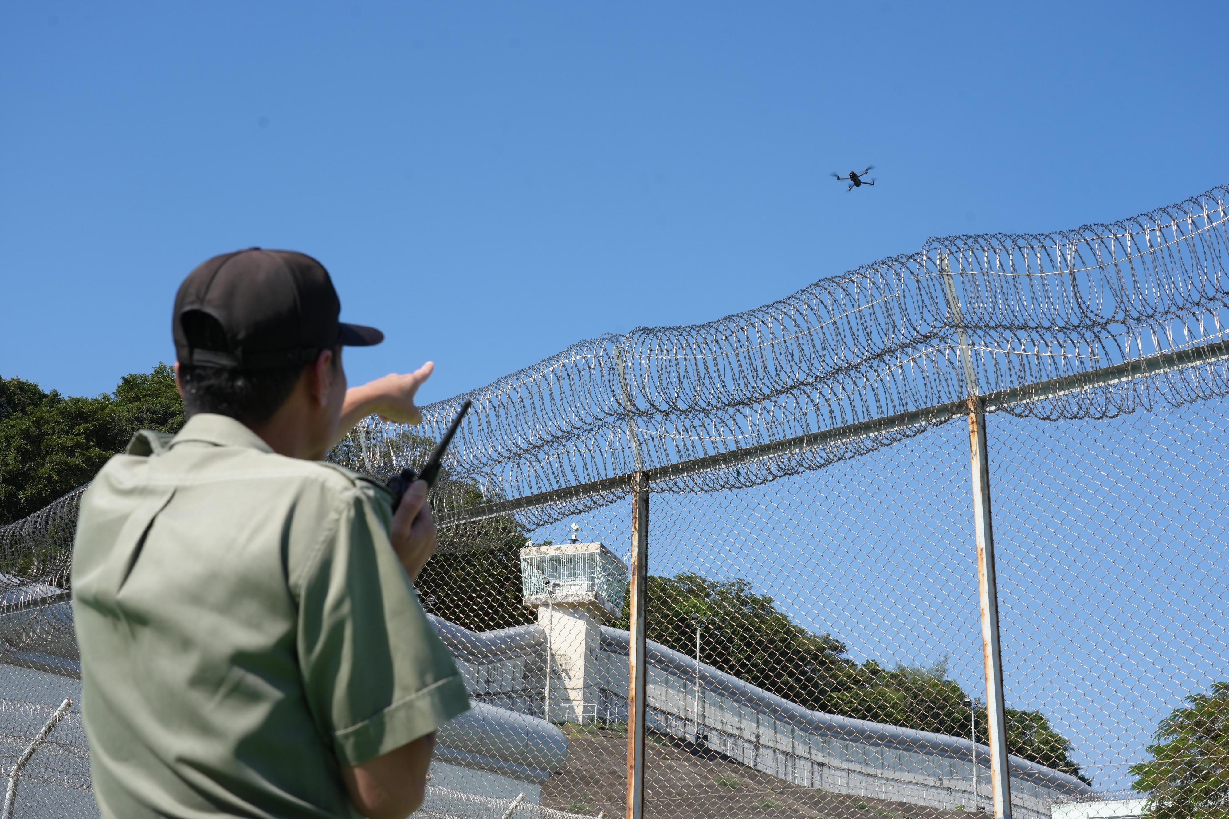 The Correctional Services Department conducted a large-scale emergency exercise, code-named "Concord XXV", at Pik Uk Correctional Institution (PUCI) today (October 21). The exercise simulated a series of incidents, which included fighting among remand persons in custody, a hostage-taking situation, a fire breakout, a mass riot and the discovery of explosives. Photo shows a correctional officer spotting a drone hovering over PUCI and immediately reporting the latest situation to his superiors via a walkie-talkie.