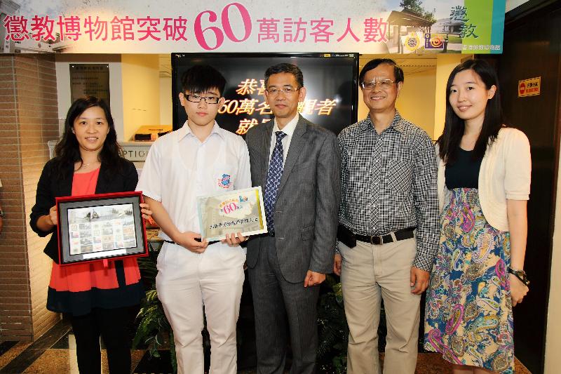 惩教署助理署长（人力资源）胡英明（中）致送纪念品予黄文彬（左二），恭贺他成为香港惩教博物馆第六十万名访客。